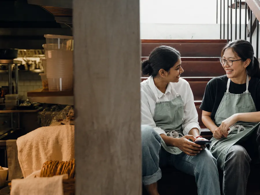 Two Monterra kitchen staff on a break, placing an order on a phone